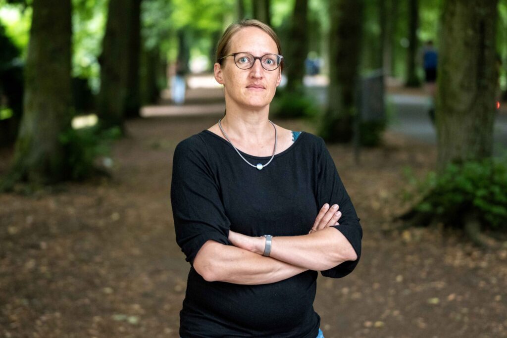 Sprecherin Birgit Wolters steht mit ernstem Gesichtsaudruck auf der Promenade